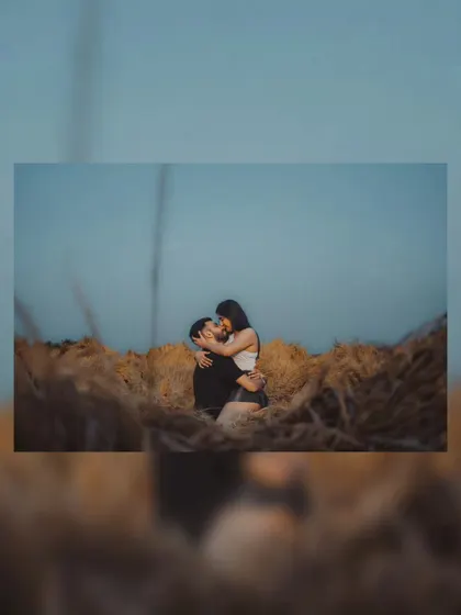 A creative shot of a couple's kiss, framed by the natural landscape. We love finding unique angles and perspectives to make your pre-wedding photos stand out.