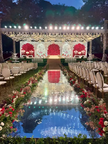 A wide view of the entire ceremony setup, with the magnificent stage, reflective aisle, and elegant guest seating.