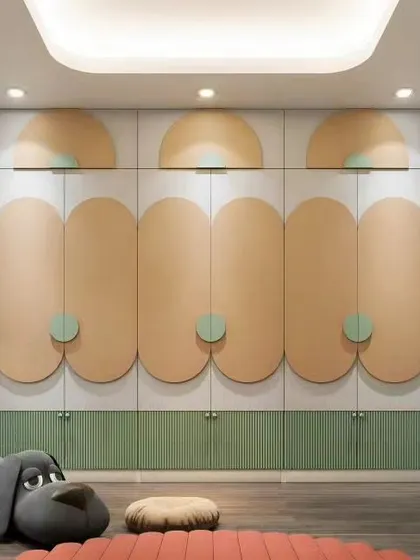 A playful kid's room featuring a custom wardrobe with rounded, overlapping doors in pastel colors. The design is soft and imaginative, with a friendly stuffed dog adding to the charm.