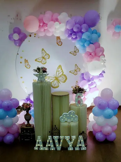 A delicate and dreamy butterfly theme for Aavya's 6th birthday. We used a pastel palette of purple, pink, and blue balloons, a backdrop with golden butterflies, and fluted pedestals for an elegant and modern look.