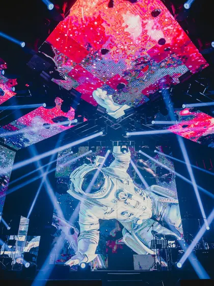 A close-up of the astronaut projection on a massive LED screen, surrounded by dynamic blue laser lights. This high-tech setup was central to our 'Infinity and Beyond' party theme.
