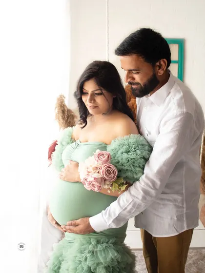 A gentle and loving moment between parents-to-be. This candid shot by the window uses natural light to create a soft and beautiful image.