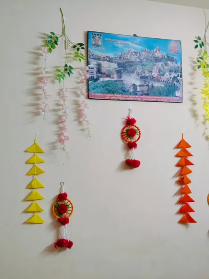 A close-up of a wall decorated with handmade paper hangings, small dream catchers, and artificial vines. This shows how I can add festive touches to any corner of the house.