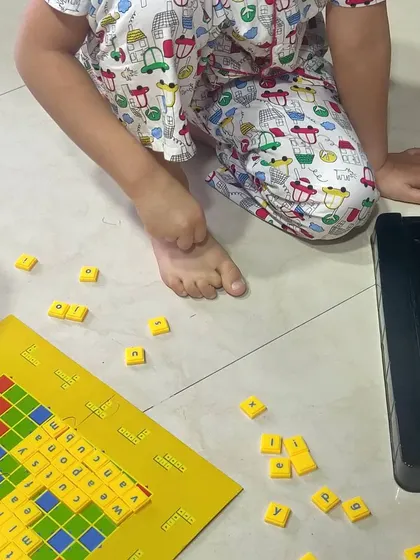 Another view of our Scrabble session. Having the letter tiles spread out encourages exploration and experimentation with different word combinations.