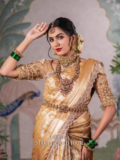 A striking pose of a bride in a golden saree, looking up with confidence. The red lipstick and defined eyes create a powerful and classic bridal look.