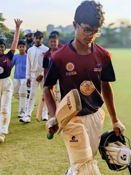 The walk of a focused batsman. A young player from our academy heads off the field after a practice session, equipped with professional gear and the determination to improve.