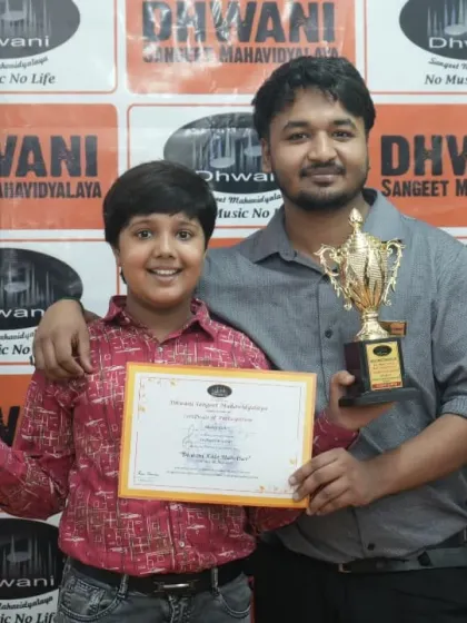 A student poses with his teacher after receiving two awards for his performances.