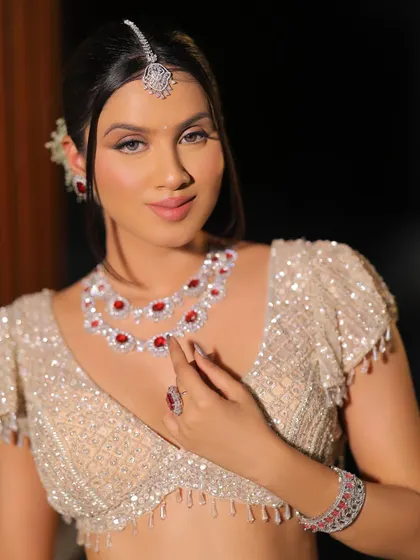 A confident pose showing off the stunning ruby and diamond necklace. The makeup is kept soft and neutral to let the jewelry make a statement.