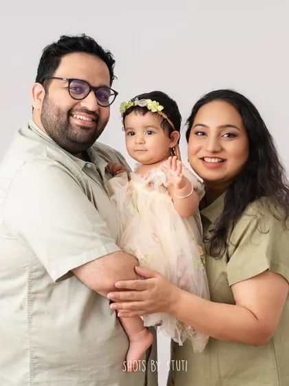A slightly different pose from the same family session, with the baby waving. I take many shots to capture a variety of interactions and expressions, ensuring a diverse gallery of images.