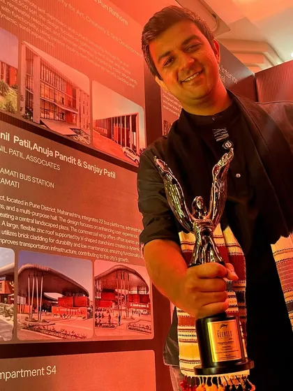 **People of Compartment S4: Kishan Shah:** Kishan holding an award, a testament to his and the team's dedication to creating impactful design.