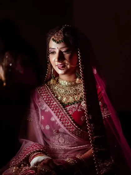 A dramatic, low-key portrait of a bride, with light just catching the details of her face and jewelry.