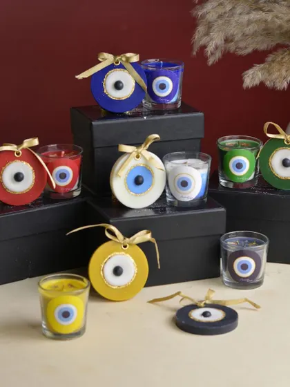 A vibrant display of my Evil Eye candles and wax sachets in various colors. Each color, from blue for protection to yellow for vitality, comes with its own unique and soothing fragrance.