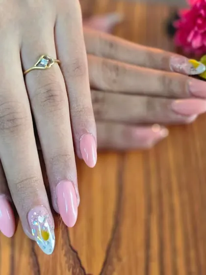 The finished look for makeup artist Prajakta. A lovely set of pink nails with a delicate, encapsulated flower accent nail.