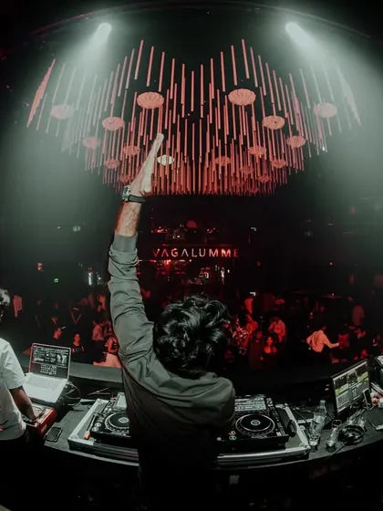 Every beat is a heartbeat. A powerful, spotlit shot from Vagalumme, capturing the connection between the DJ, the music, and the crowd.