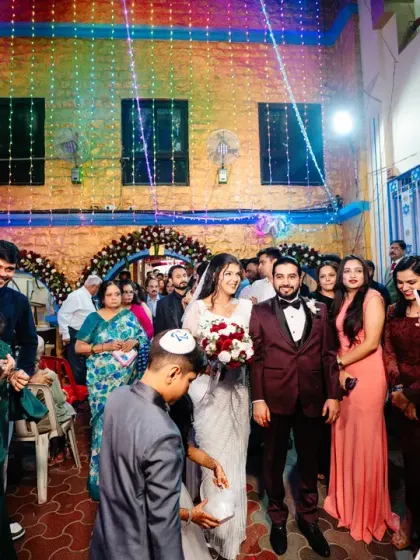 The "just married" couple makes their way through a crowd of well-wishers at their Jewish wedding.
