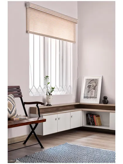 A simple, bright corner with low-height storage and a comfortable chair, perfect for reading or enjoying a cup of tea.