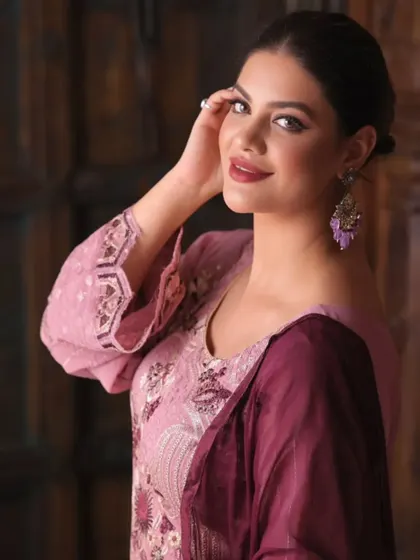 A close-up portrait from an apparel shoot, focusing on the model's expression and the details of the earrings and neckline embroidery. This type of shot adds a personal touch to a product listing.