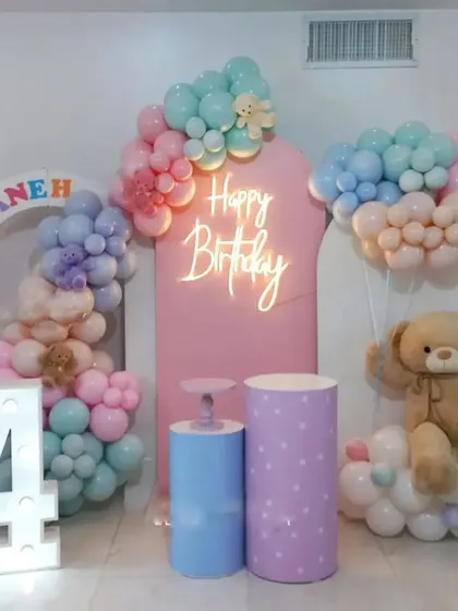 A teddy bear themed 4th birthday party. This decoration features pastel balloon clouds, a large teddy bear prop, and a marquee number '4'.
