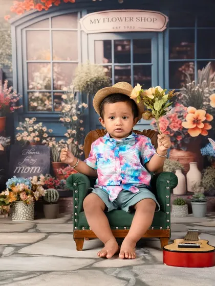 A sweet moment with the birthday boy holding a bouquet of flowers, perhaps for his mom. A heartwarming shot from his first birthday session.