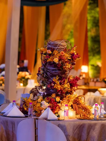 A sculptural centerpiece inspired by the work of international designer Hitomi Gilliam. This arrangement uses midollino extenders to create a dynamic, woven structure through which vibrant flowers burst forth, blending technique with natural beauty.