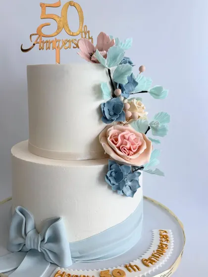 A close-up of the beautiful sugar flower cascade on the 50th-anniversary cake, highlighting the mix of blue and pink blossoms.