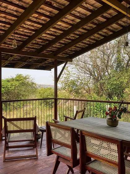 The spacious veranda of the prefab cottage serves as an outdoor dining and living room. With a tiled roof for shade, it’s the perfect place to enjoy the surrounding nature, blurring the lines between inside and out.