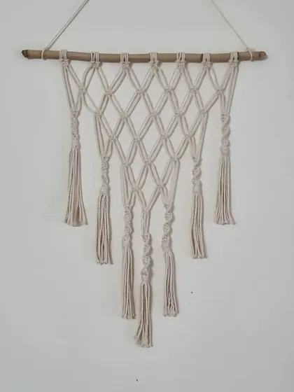 A simple yet elegant macrame wall hanging featuring a diamond pattern and spiraling knots. It's a versatile piece that fits beautifully in any space.