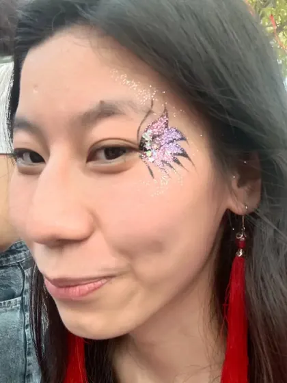 A close-up of a butterfly with pink and silver glitter. The black outline provides a strong contrast that makes the colors pop.