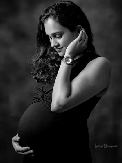 A quiet, introspective moment captured in timeless black and white. This portrait focuses on the gentle connection between a mother and her unborn child.