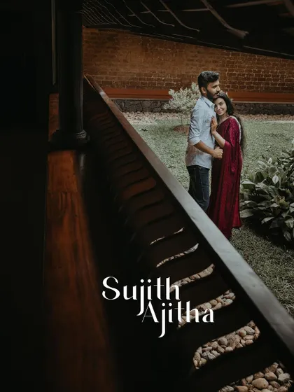 A beautifully composed shot of a couple seen through the railing of a traditional veranda.