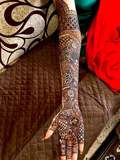 A single arm view of a full bridal design. The pattern is a beautiful mix of florals, paisleys, and geometric shapes, creating a rich and textured look.
