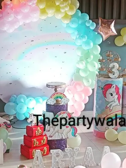 A pastel unicorn theme for a 3rd birthday, featuring a large foil balloon number and character cutouts.