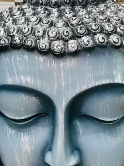 Another example of a custom-painted Buddha statue. This one has a beautiful light blue finish with a distressed, brushed effect, giving it a unique, artistic look.