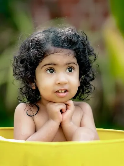 A sweet and curious expression from a little girl in our yellow water tub. We capture the quiet moments of wonder too.