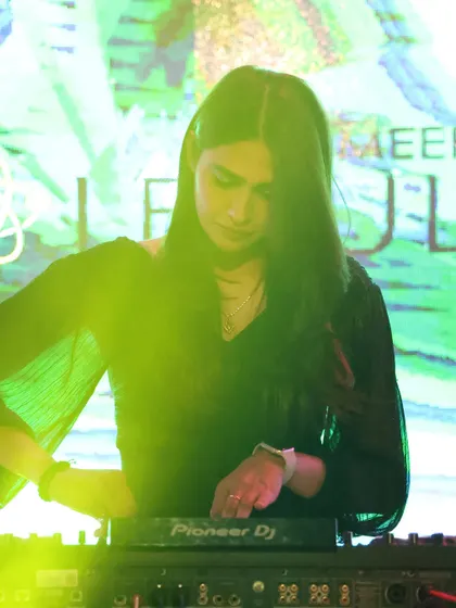 Mixing tracks against a vibrant green LED background at Molecule Meerut. The visuals are always synchronized with the music to enhance the experience.