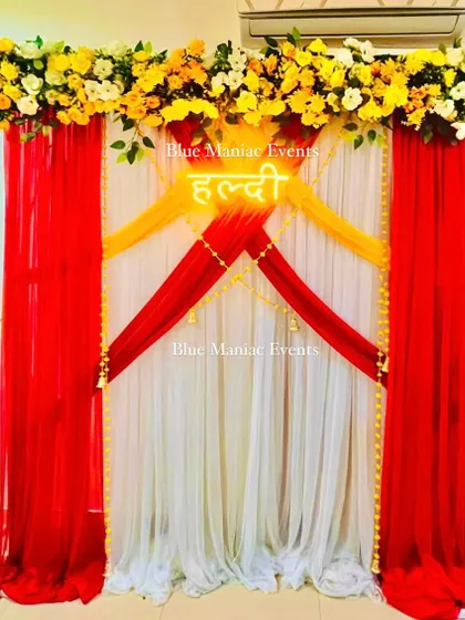 Another shot of the red and yellow Haldi backdrop, showing the 'Haldi' neon sign that adds a modern touch.