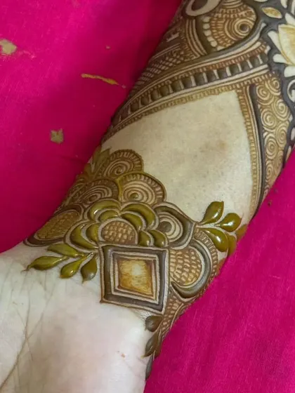 A close-up of a wrist cuff design. The pattern is geometric and modern, showing the versatility of henna art.