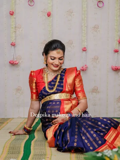 A radiant mom-to-be at her Seemantham (baby shower) in Charlotte, NC, dressed in a traditional blue and red saree.