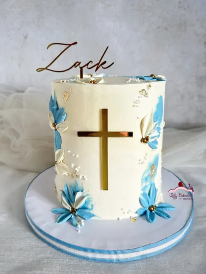 A beautifully crafted communion cake. I used a palette knife to paint the blue and white buttercream flowers, framing a simple gold cross.