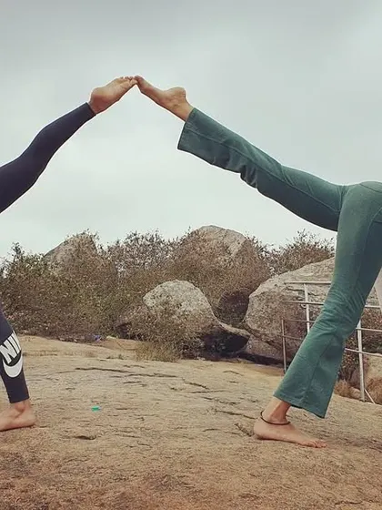 A partner version of the three-legged downward dog pose, creating a beautiful symmetrical shape. This kind of practice builds communication and trust.