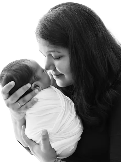 A tender black and white portrait of a mother holding her newborn baby, nose to nose. This image beautifully captures the immediate and deep connection between mother and child.