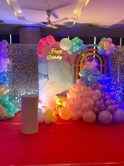 A dreamy teddy bear themed birthday with pastel rainbow balloons. This stage setup includes two shimmer walls, a custom backdrop, and cute teddy bears for a soft, playful look.