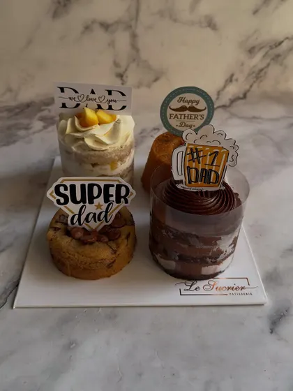 This Father's Day assortment platter comes with fun, themed toppers. The set includes a Mango Vanilla Cake, Date Walnut Tea Cake, a gooey cookie, and a decadent chocolate cake.