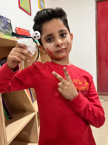 Peace out from a cool ghoul! He’s proudly holding up the ghost lollipop he made during our spooky Halloween session.