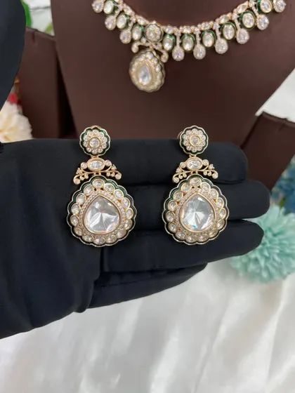 The earrings and maang tikka from our Amaya Premium Moissanite Kundan set. Notice the delicate Meenakari border and the large central stone.