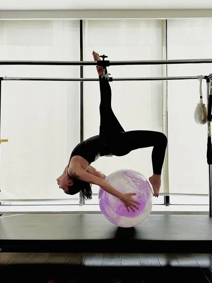 A beautiful and challenging pose combining a backbend and leg extension on the Cadillac.