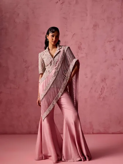 This ensemble redefines the saree with its flared pants and a structured, collared blouse that extends into a fringed pallu. It's a fashion-forward choice for someone who loves to experiment with their style.