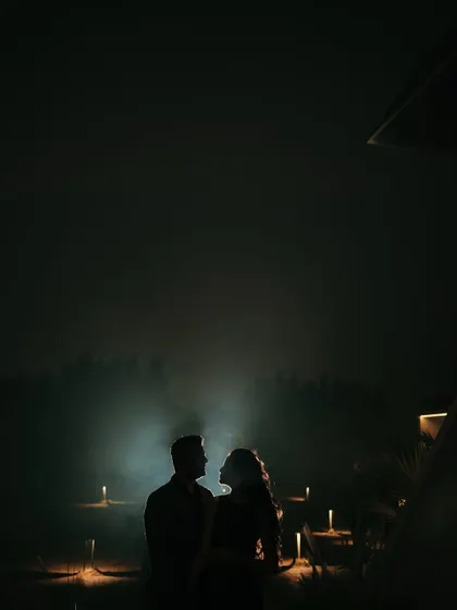 A stunning silhouette of the couple against a mysterious, foggy backdrop lit by candles. This highly atmospheric and dramatic shot is perfect for a save-the-date announcement.