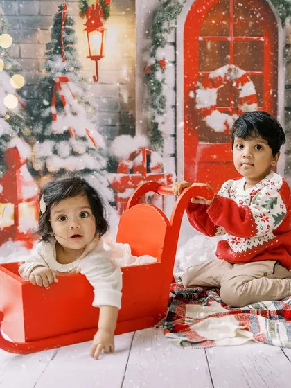Siblings playing in a festive red sleigh. A fun and playful shot that captures the spirit of the holidays.