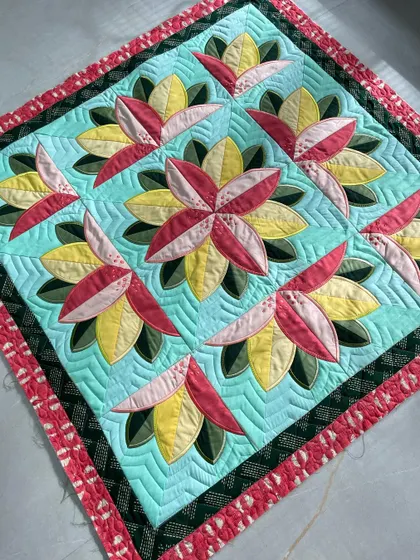 An angled view of the "Big Bloom" wall quilt, highlighting the 3D effect of the petals.